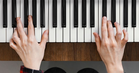 Imagen de dos manos tocando un piano