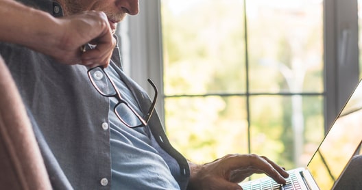 Imagen de un hombre navegando por internet con un portátil